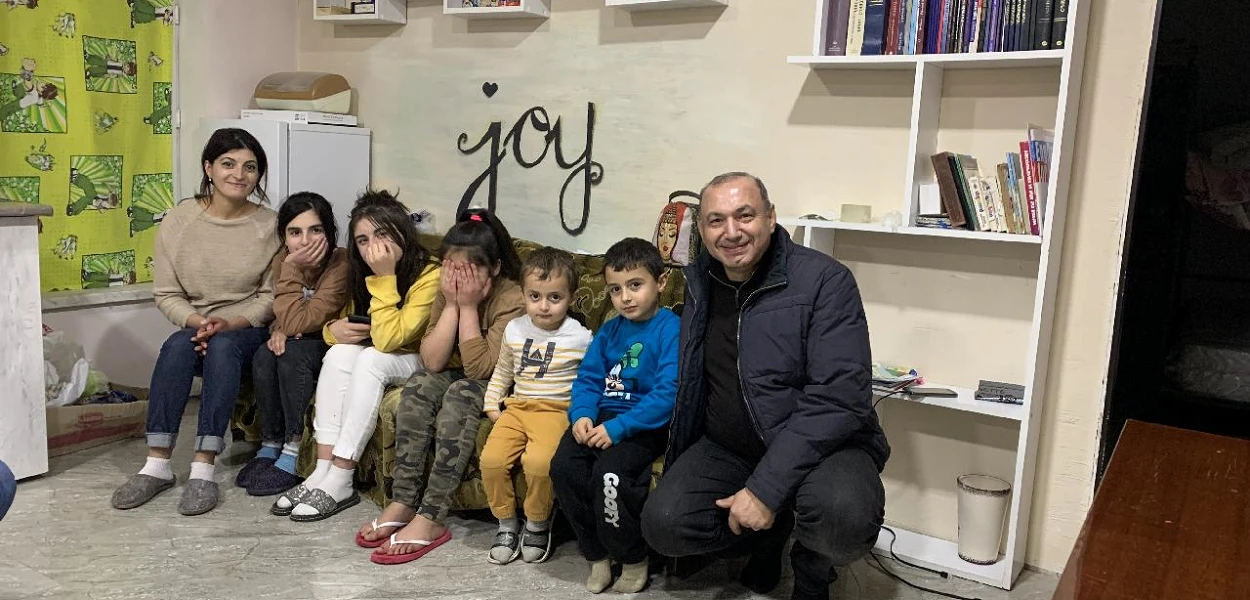 Az anyát öt gyermekével elüldözték Susiból, azóta Örményországban élnek. A lelkész (jobbra) gondoskodik a menekültcsaládról. | © CSI